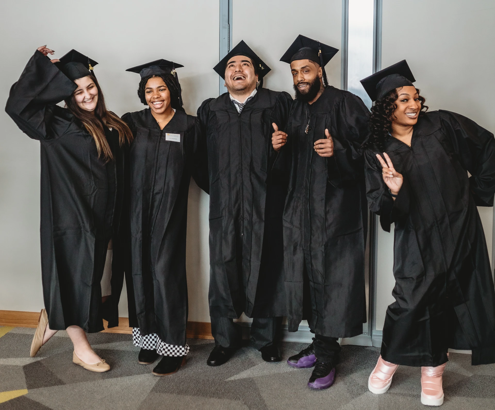 A group of people in graduation attire posing for the camera.