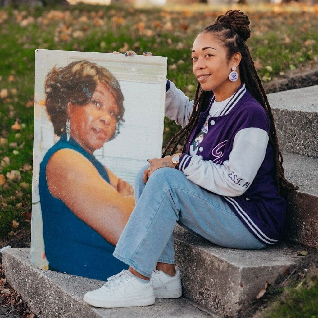 A girl sitting on steps holding up a picture.